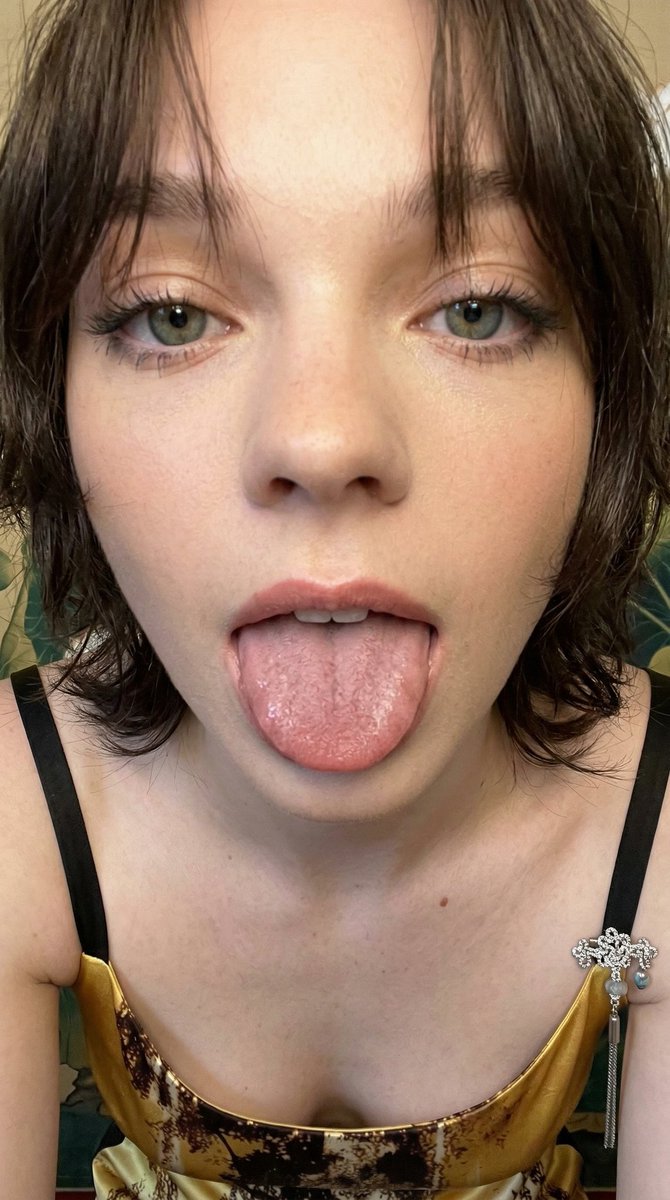 一张极近距离的智能手机业余特写肖像，捕捉到一位年轻女性面部的下半部分，她顽皮地将舌头伸向镜头。主体伸出舌头，展现出宽阔平坦的肌肉表面，布满细密…, 图片 2