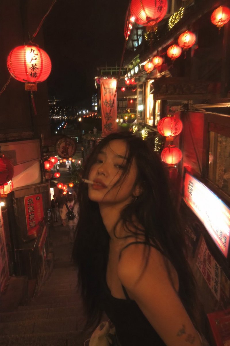 失焦抓拍风格的照片：一位亚洲时装模特站在夜晚的台湾老街中央，四周环绕着发光的红色灯笼。香烟美学氛围，暖色调，Pinterest 风格感觉。, 图片 1