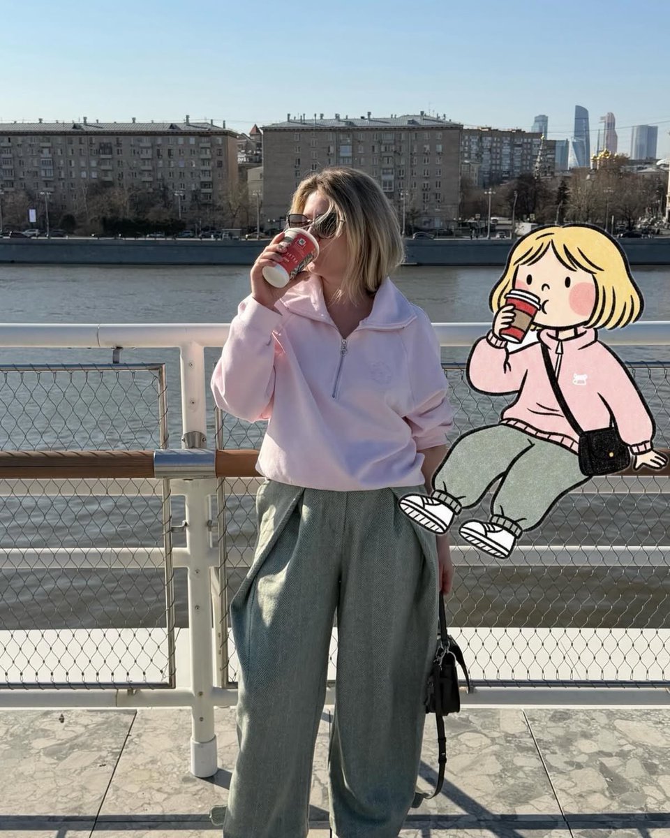 柔和的抓拍街头摄影,一位时尚女性站在河边渡轮甲板上,手持红色外带杯喝咖啡,晴朗午后光线,柔和粉彩色调,超大浅粉色半拉链卫衣,宽松灰色长裤,黑色…, 图片 1