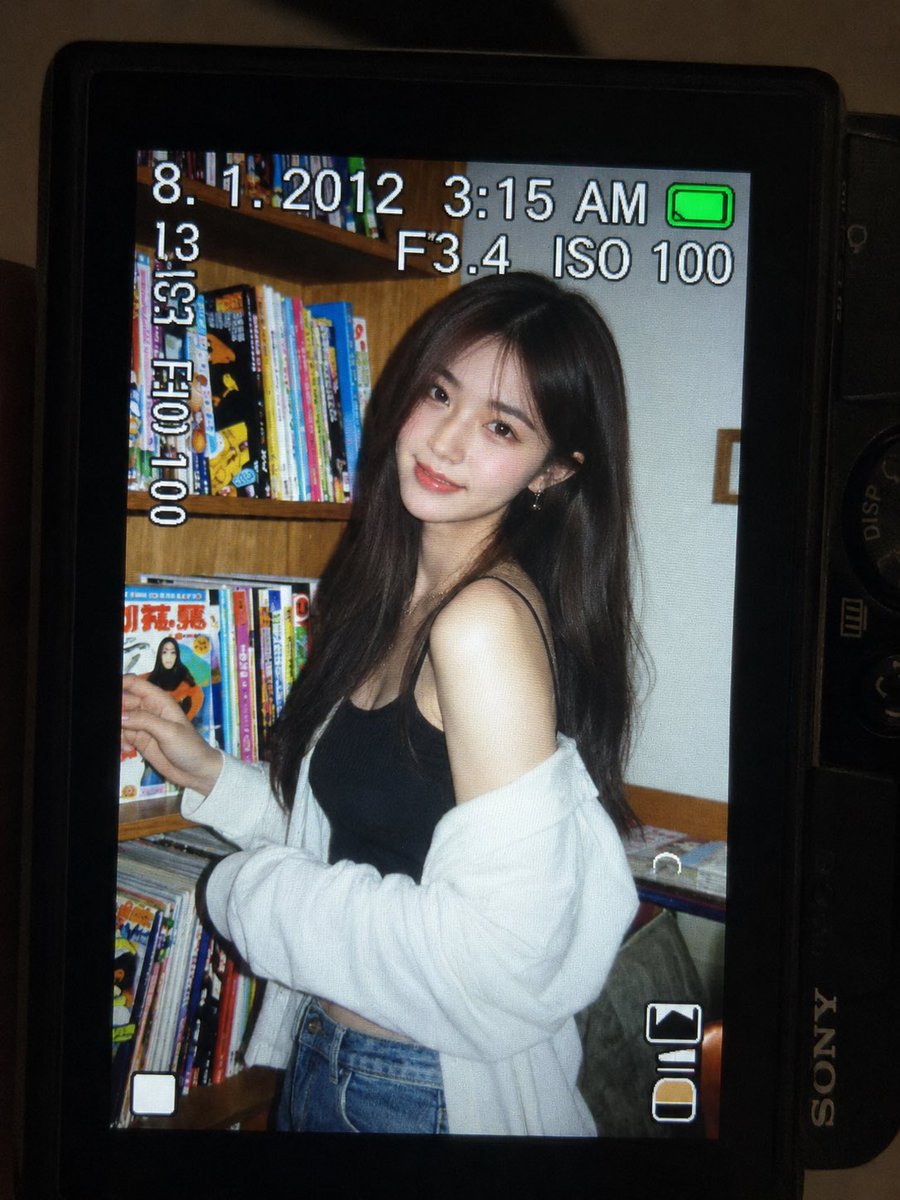 一张超精细的特写镜头：一台微型紧凑型数码相机的 LCD 屏幕在原本黑暗的室内房间中明亮发光。屏幕上是一张 2010 年代初期的随性傻瓜相机快照…, 图片 2