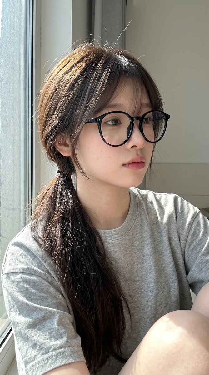 超写实抓拍式智能手机自拍照肖像：一位年轻东亚女性室内坐在一扇大窗户旁，处于明亮的自然日光下。保持与上传的面部参考高度相似的面部特征：柔和的椭圆…, 图片 2