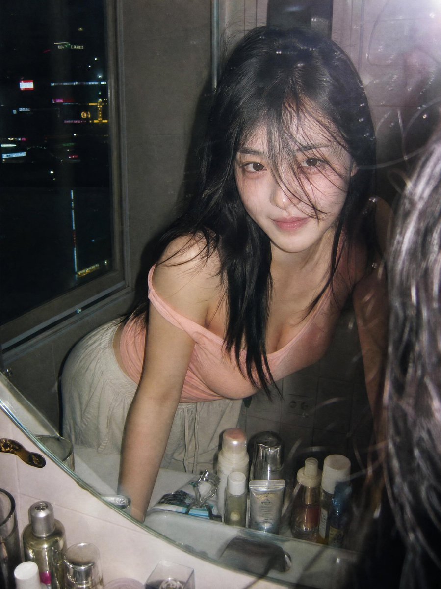 超写实抓拍胶片摄影人像：一位年轻女子夜晚俯身在浴室洗手台前，透过镜子凝视自己。画面通过一面略有污渍的镜子拍摄，呈现自然的反射与细腻的瑕疵。她留…, 图片 2