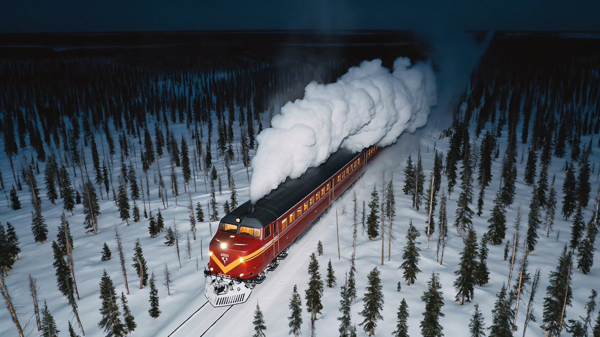 编辑所附的航拍夜景图片：一列红色西伯利亚大铁路（Trans-Siberian）机车正穿过白雪覆盖的西伯利亚针叶林（taiga）。, 图片 1