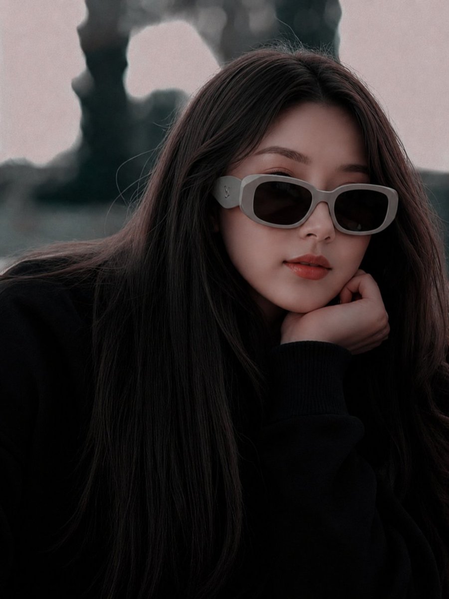 超现实电影级时尚人像:一位美丽的年轻东亚女性,长直深棕色头发,身穿超大黑色毛衣,佩戴厚重的哑光灰色奢侈品牌设计师太阳镜。她将下巴轻搁于手上,神…, 图片 1