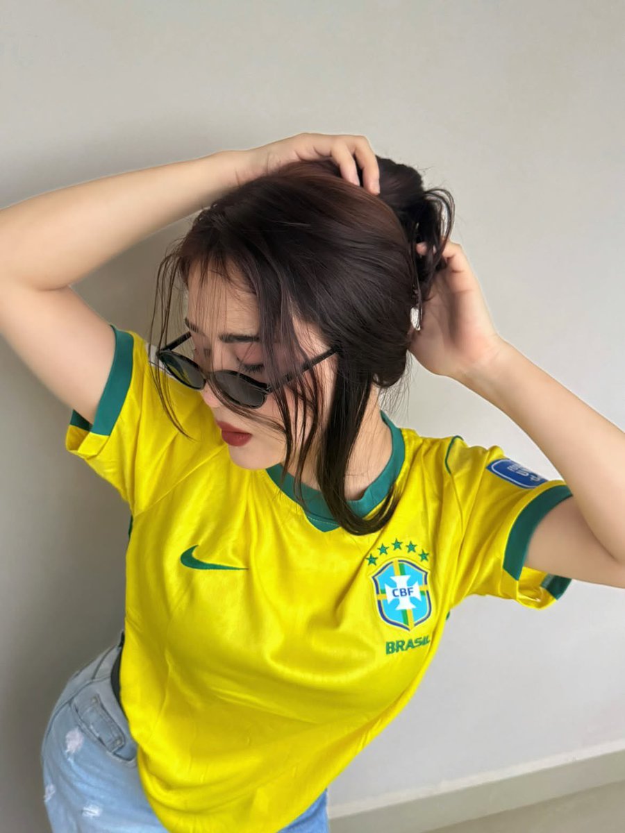 超现实风格的时尚人像摄影：一位时髦的年轻女性，身穿不同国家队的足球球衣（阿根廷、葡萄牙、巴西），在室内一面干净极简的米白色墙壁前自信地摆姿势。…, 图片 3