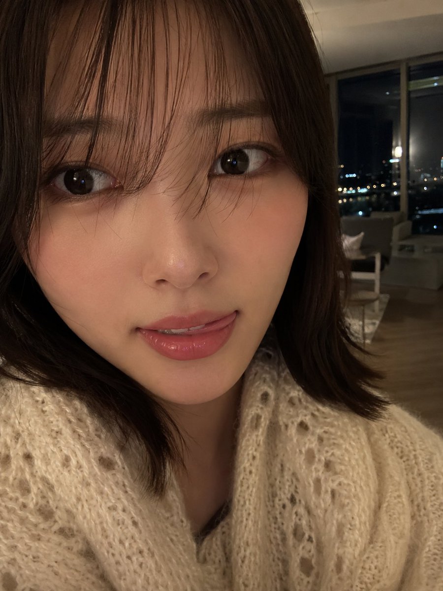 室内夜景中，使用智能手机摄像头拍摄的年轻女性超写实特写自拍肖像。肌肤柔和自然，肤质光滑细腻，双颊微微泛红，嘴唇粉嫩水润，表情俏皮，舌头轻触上唇…, 图片 2