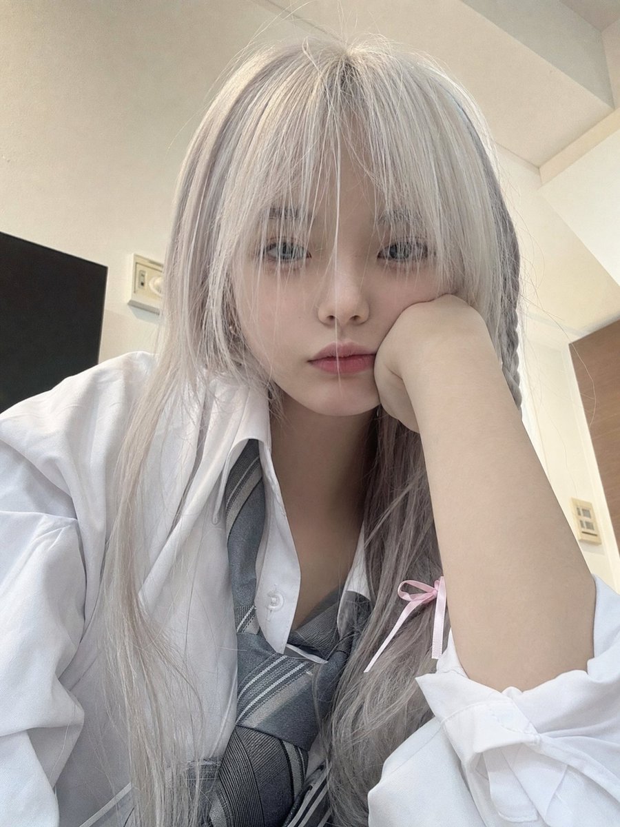 一位年轻的日本女孩,留着长长的银白色头发,柔软凌乱的刘海部分遮住眼睛,侧面编着一条用粉色丝带扎住的小辫子,穿着白色纽扣校服衬衫、灰色领带和校服…, 图片 2