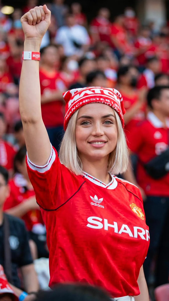超现实的体育生活方式编辑风格人像：一位惊艳的女性足球迷，留着利落的铂金金色波波头发型，眼神呈冰蓝偏绿色，皮肤纹理自然，妆容柔和，神态自信。她身…, 图片 1