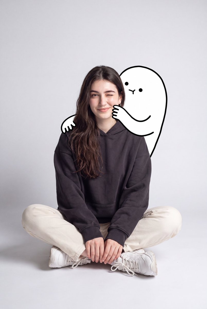 一幅可爱的极简风肖像:一位年轻女性随意地坐在地板上,身处一个光线柔和的灰色背景的简洁摄影棚中。她穿着一件宽松的深炭灰色连帽衫、奶白色直筒长裤、…, 图片 1