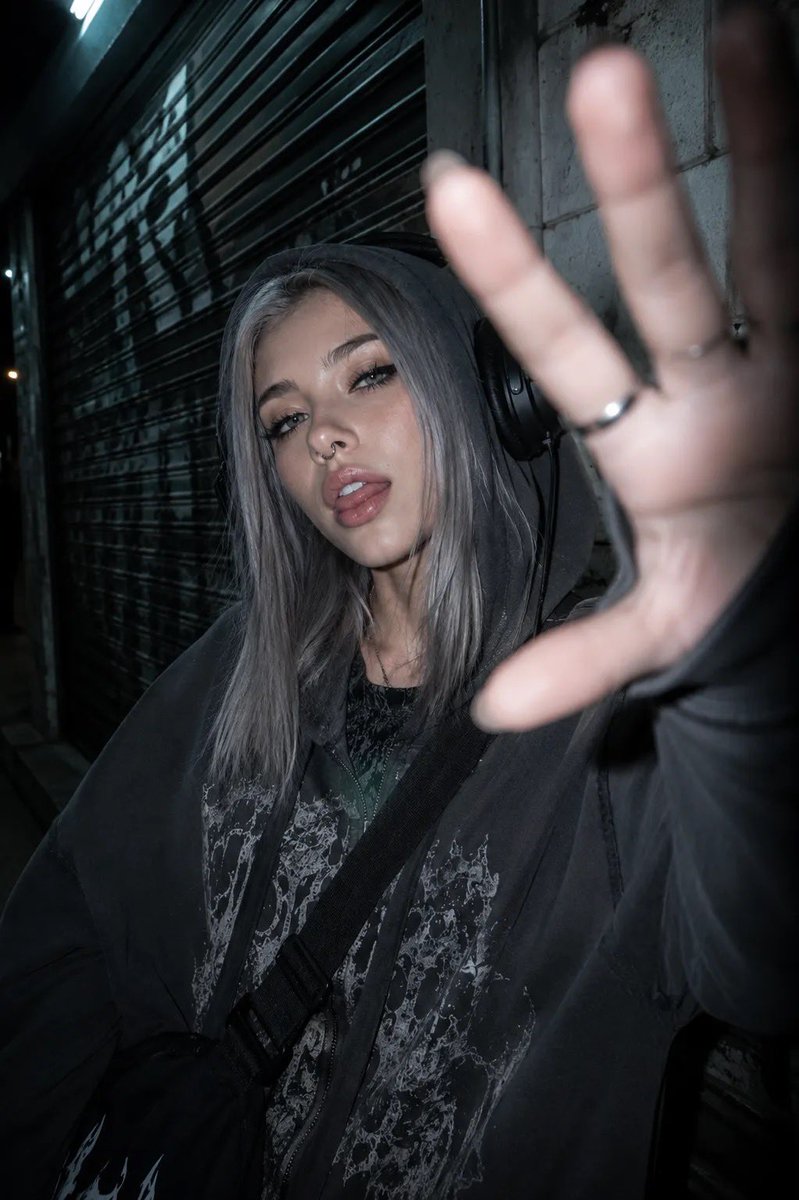 以所附照片为参考,创作一张夜间城市摄影人像,主体为一位年轻女性,整体呈现另类、垃圾摇滚(grunge)美学。她留着齐肩直发、中分,浅色眼睛搭配…, 图片 4