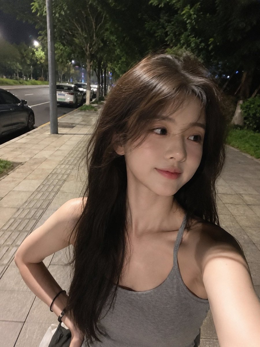 夜晚用手机拍摄的极致真实感智能手机自拍,看起来确实是用 iPhone/手机摄像头抓拍的,而不是单反相机。一位美丽的年轻东亚女性,留着浓密略带凌…, 图片 2