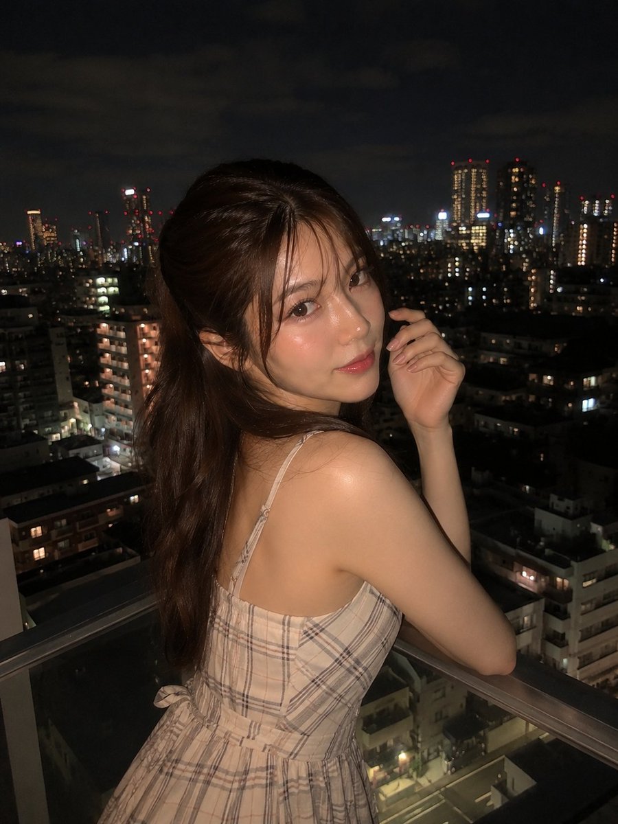 超写实夜景人像:一位美丽的年轻女子站在阳台上,俯瞰城市天际线,身穿优雅的无袖米色格纹连衣裙,淡雅腮红妆容,自然水润唇妆,慵懒的半扎发造型,几缕…, 图片 1