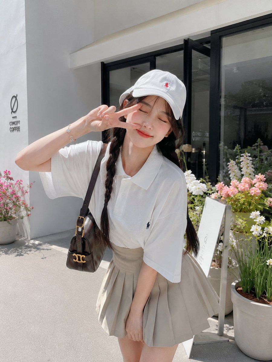 一张迷人的、照片写实风格的生活方式人像照:一位美丽的年轻日本女性,在晴朗的阳光下,于一家现代极简风格的咖啡馆外俏皮地摆姿势。她微微前倾,在脸旁…, 图片 2
