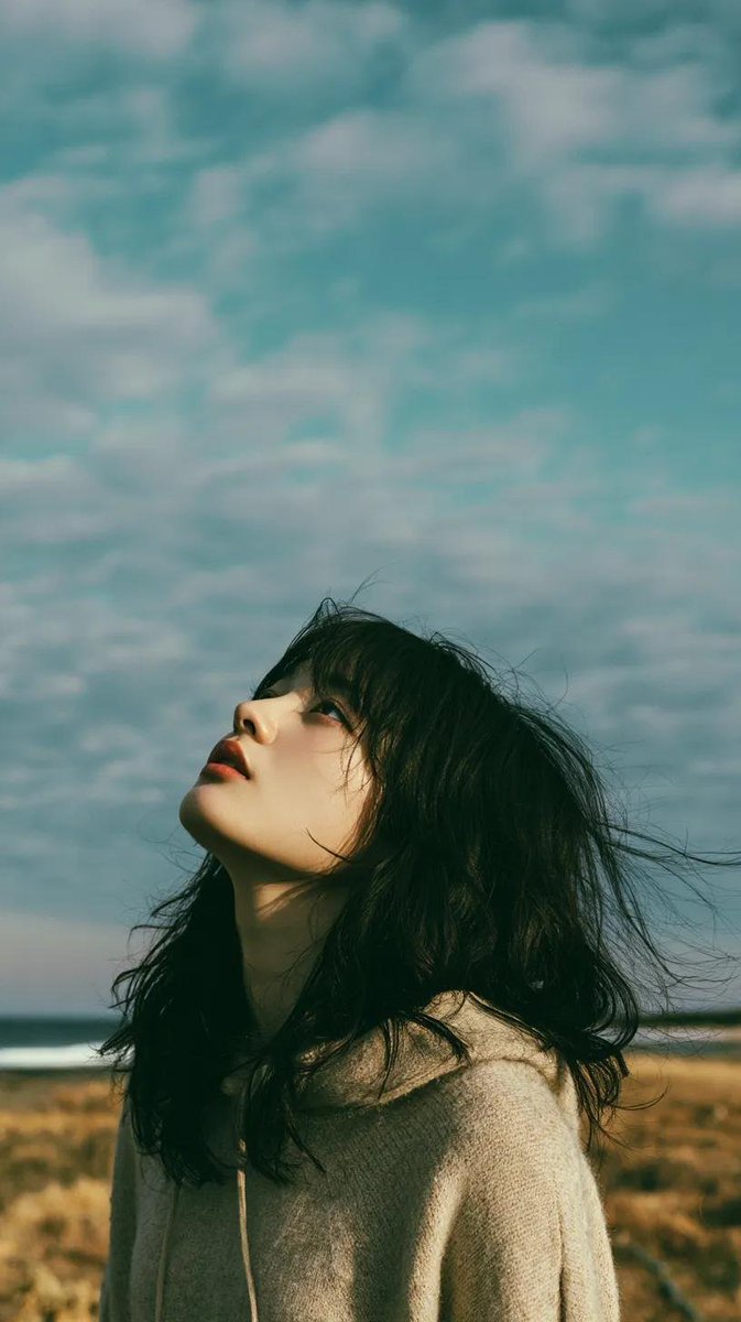 电影极简风格肖像：一位美丽的年轻东亚女性独自伫立在开阔的野花草甸上，头顶是无限的蓝天，她双眼微闭或半睁，仰望天空，仿佛在拥抱微风。乌黑长发自然…, 图片 3