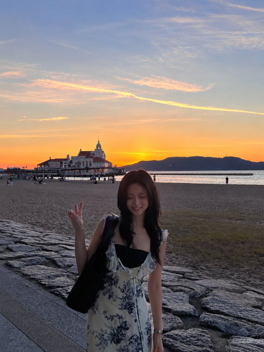 超现实电影感旅行照片:一位年轻的东亚女性站在沙滩上,沐浴在令人屏息的日落中,采用竖向 3:4 构图。她身穿一件精致的白色连衣裙,点缀着细腻的蓝…, 图片 4