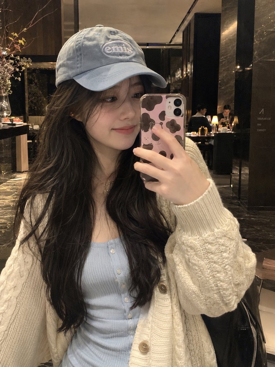 超写实自然智能手机自拍,竖向 3:4,一位年轻东亚女性的室内镜面式随性自拍,背景为一家温馨高档的餐厅或酒店大堂酒廊。, 图片 1