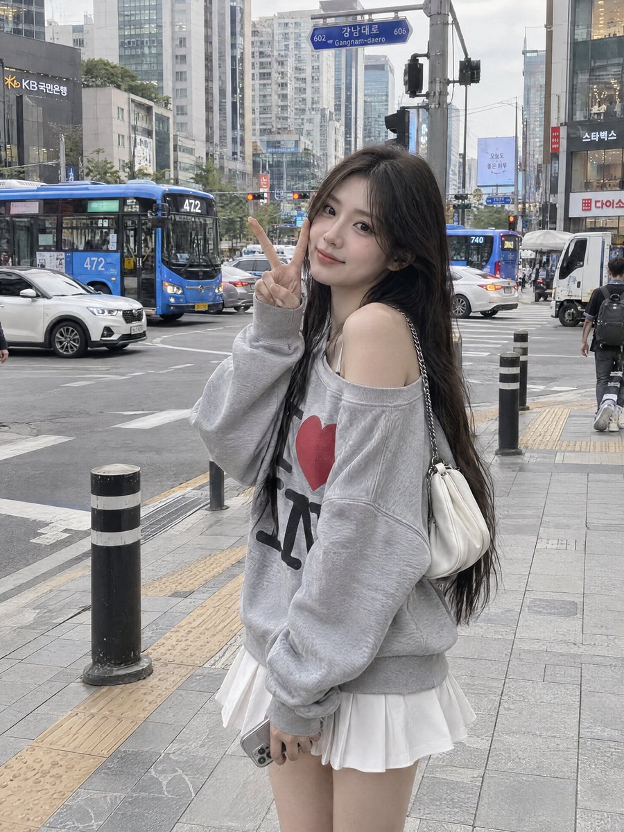 一张照片写实风格的抓拍街拍时尚肖像照,一位年轻女子站在一座大型城市十字路口繁忙的城市人行道上。她有一头非常长、直、深棕色的头发,垂顺地披在背上…, 图片 1