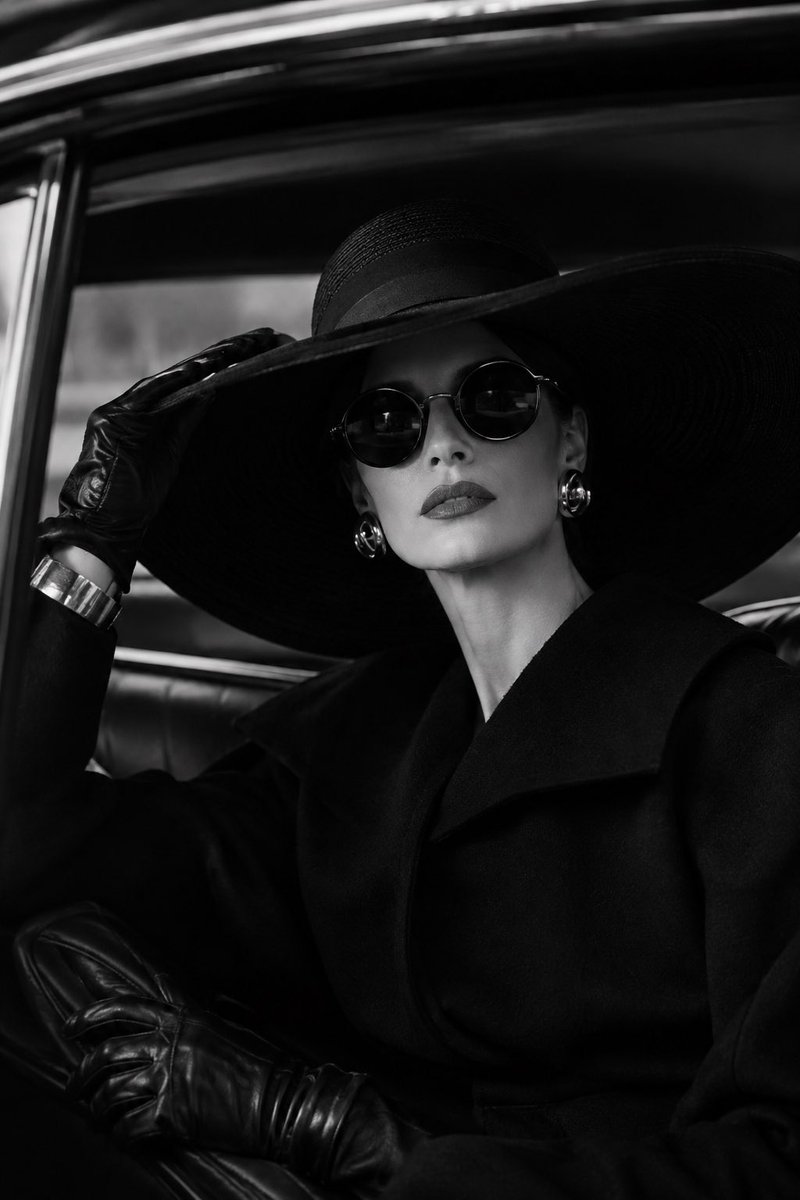 Elegant woman sitting inside a classic luxury car, wearing an oversized wide-br…