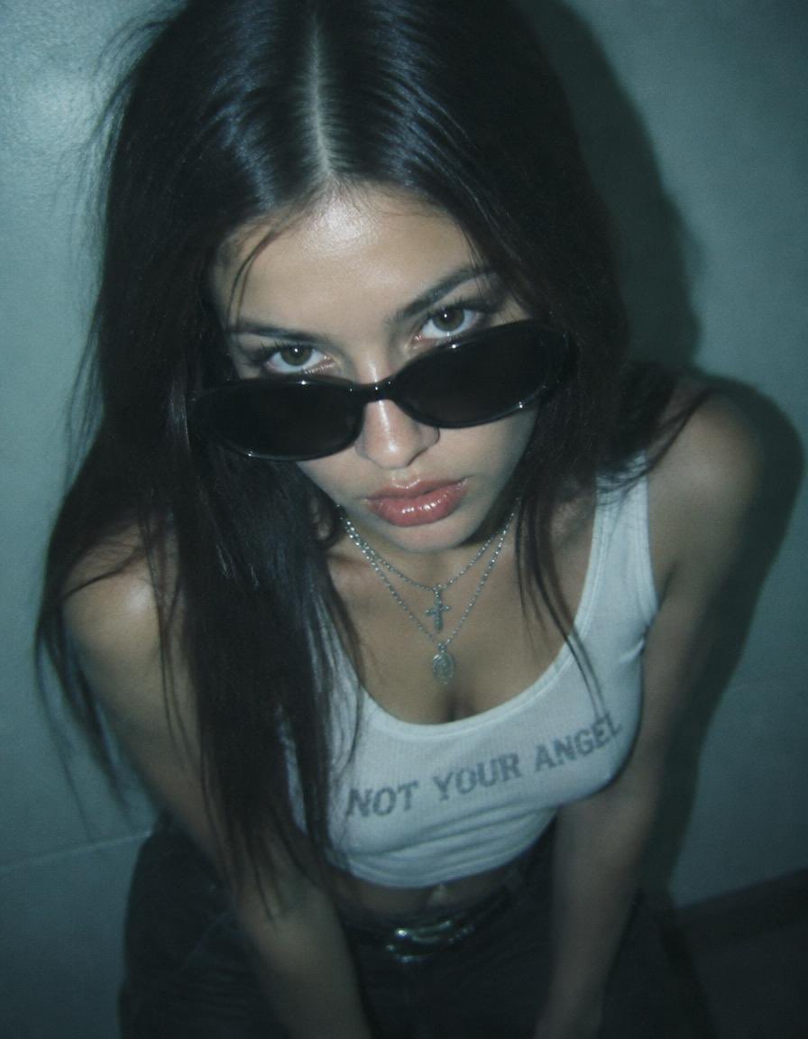 Close up shot looking down at a girl with long straight dark hair parted in the…