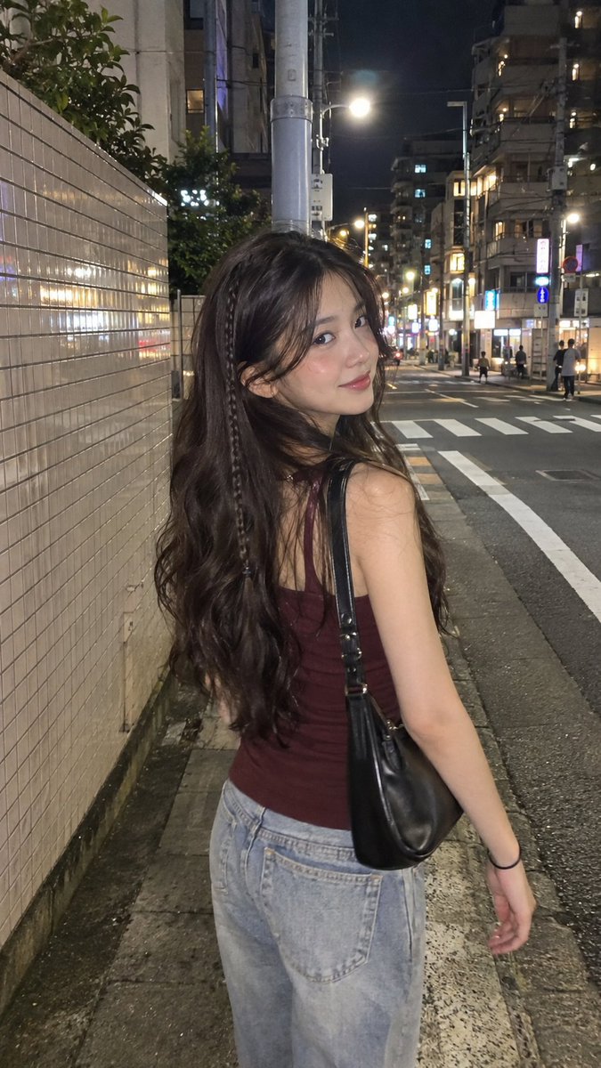 Candid cinematic iPhone night street portrait of a young woman in Japan, long w…