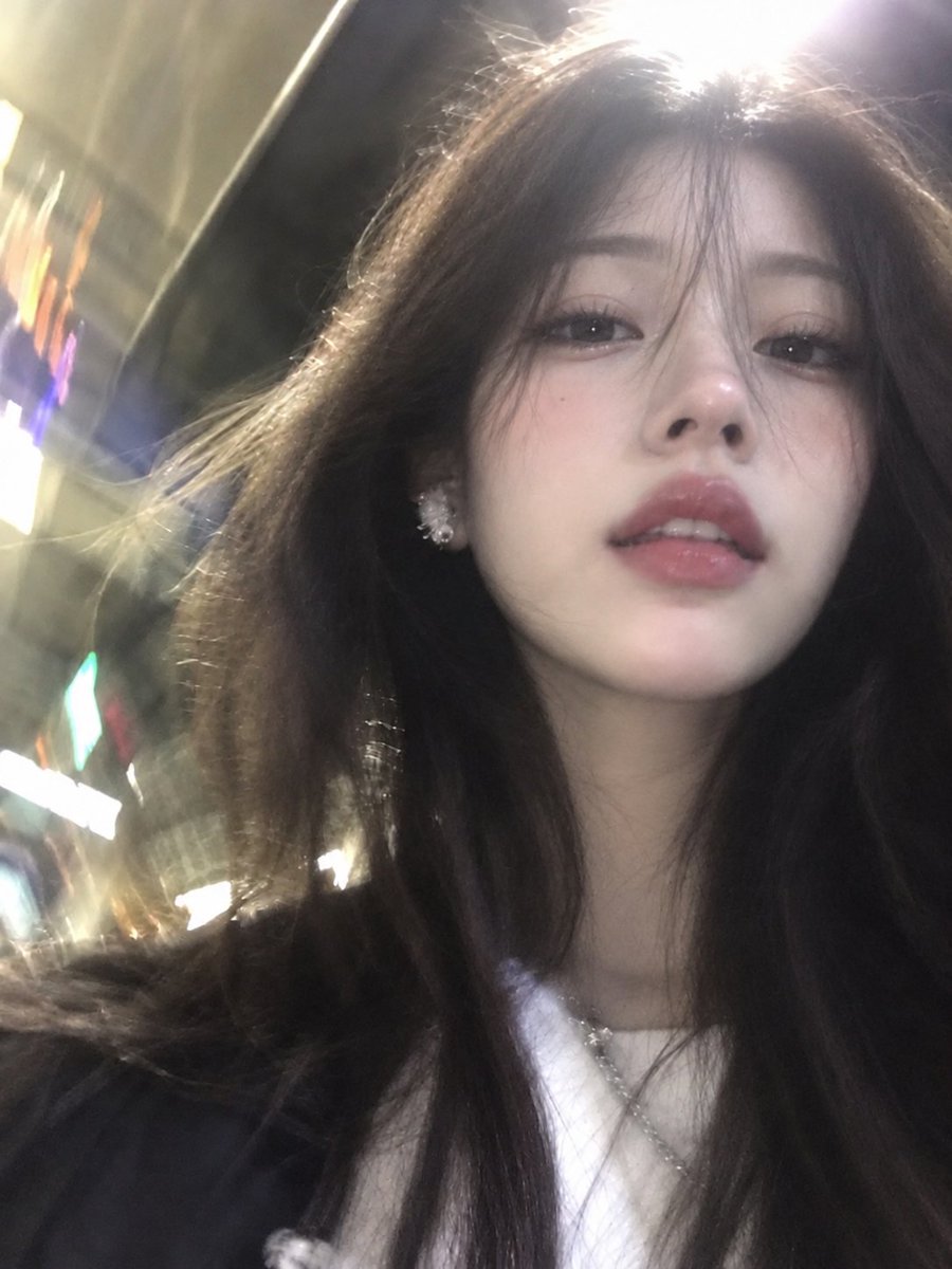 Ultra-realistic low-angle selfie of a beautiful East Asian girl with long dark …