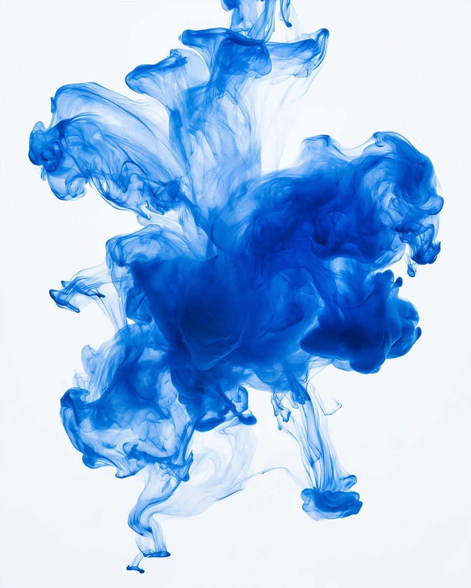 Drops of cobalt blue ink dispersing in clear water against a pure white backgro…